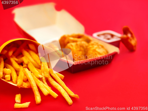 Image of chicken nuggets and french fries on red background