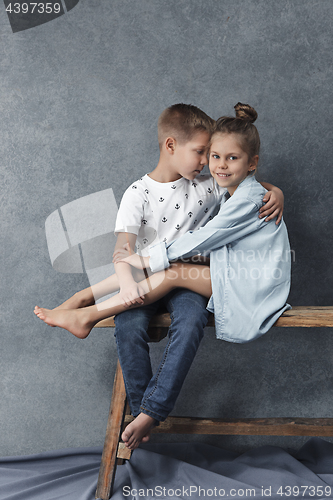 Image of A portrait of little girl and a boy on the gray background