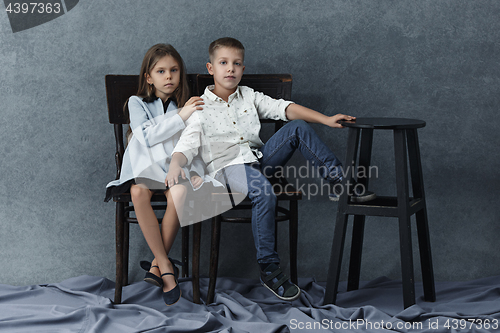 Image of A portrait of little girl and a boy on the gray background