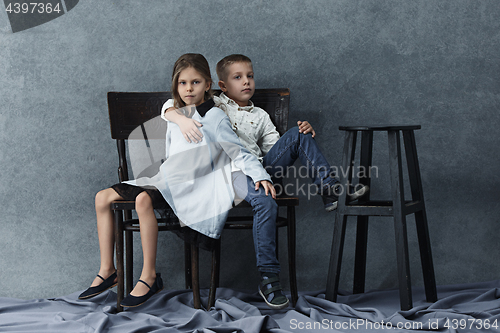 Image of A portrait of little girl and a boy on the gray background