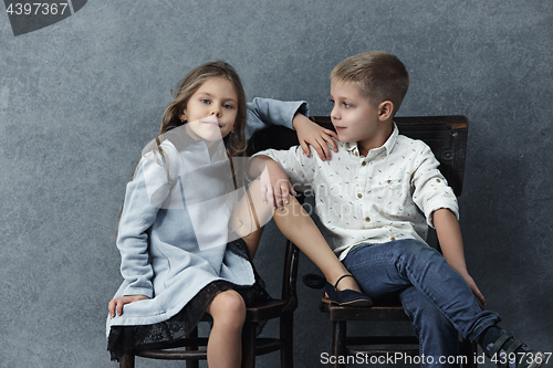 Image of A portrait of little girl and a boy on the gray background