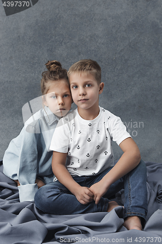 Image of A portrait of little girl and a boy on the gray background