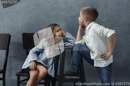 Image of A portrait of little girl and a boy on the gray background