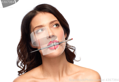 Image of beautiful woman holding make up brush for lipstick