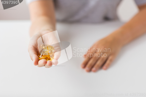 Image of hand holding cod liver oil capsules