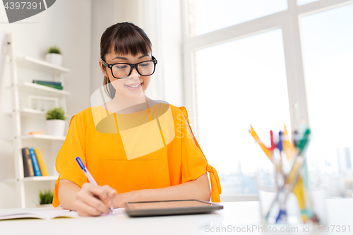 Image of asian student girl with tablet pc learning at home