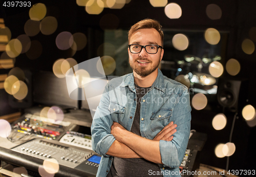 Image of man at mixing console in music recording studio