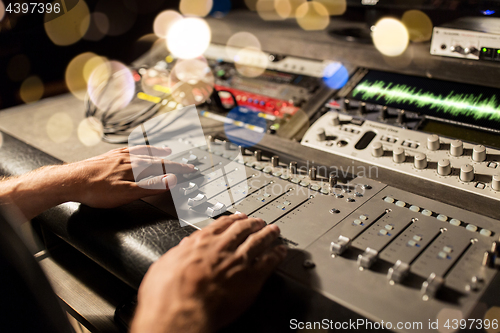 Image of man using mixing console in music recording studio