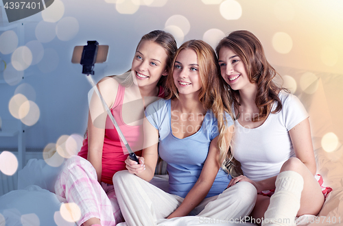 Image of teen girls with smartphone taking selfie at home