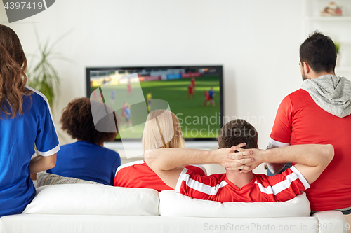 Image of friends or soccer fans watching game on tv at home
