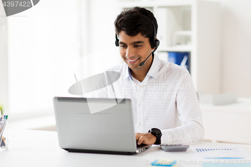 Image of businessman with headset and laptop at office