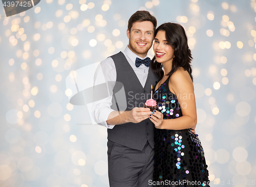 Image of happy couple with cupcake at birthday party