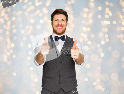 Image of happy man in festive suit pointing in camera
