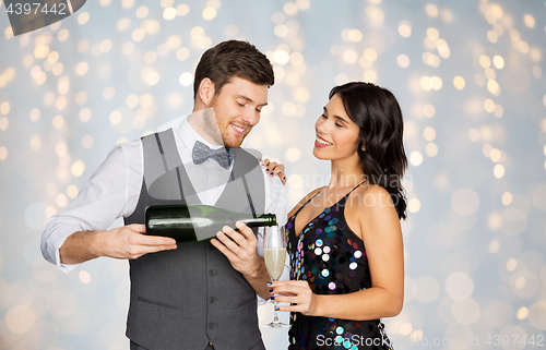 Image of happy couple with champagne and glass at party