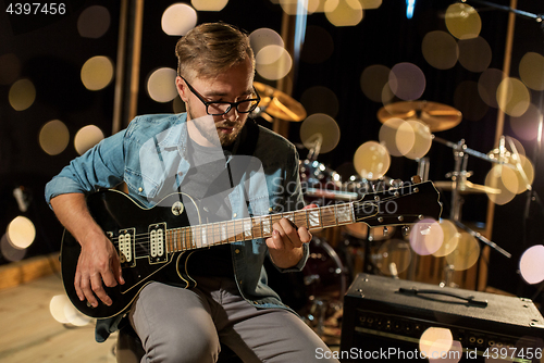 Image of man playing guitar at studio rehearsal