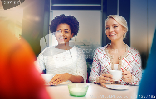 Image of happy young women drinking tea or coffee at cafe