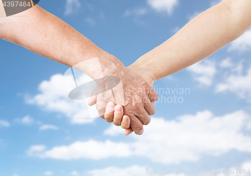 Image of close up of senior and young woman holding hands