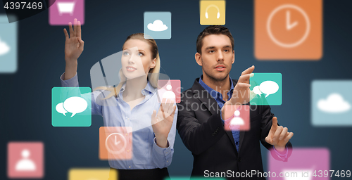 Image of businessman and businesswoman using virtual icons