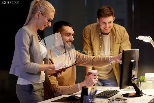 Image of business team with computer working late at office