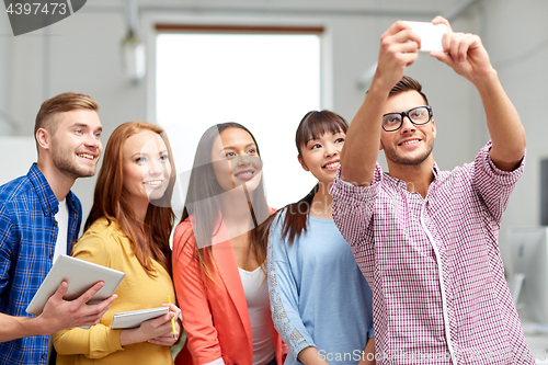 Image of creative business team taking selfie at office