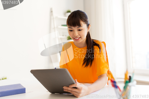 Image of asian student girl with tablet pc learning at home