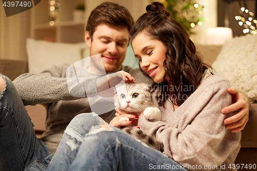 Image of happy couple with cat at home