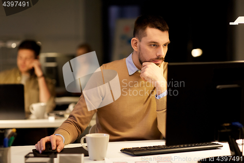 Image of man with computer working late at night office