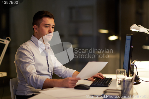 Image of businessman with computer working at night office