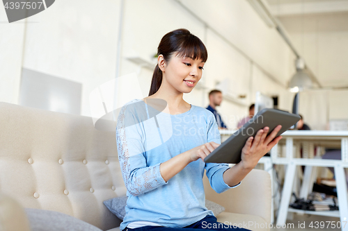 Image of happy asian woman with tablet pc working at office