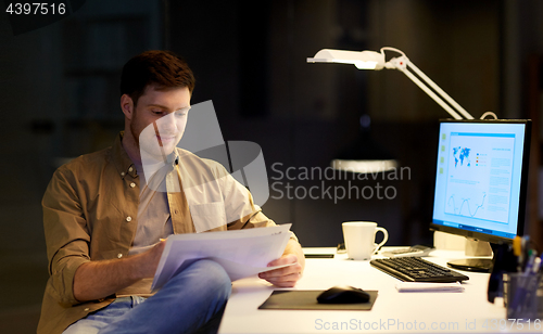 Image of businessman with papers working at night office