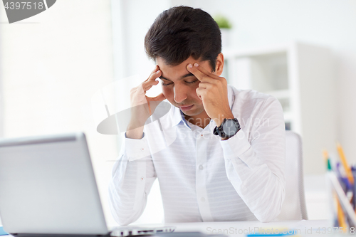 Image of stressed businessman with laptop at office