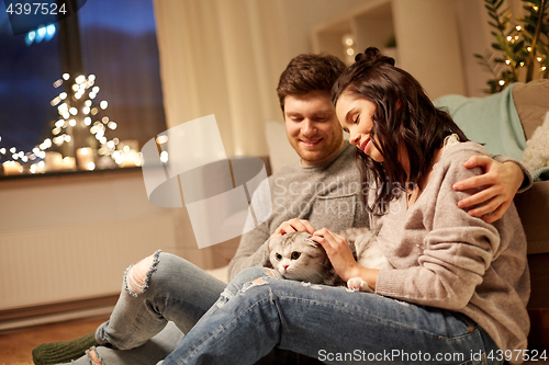 Image of happy couple with cat at home