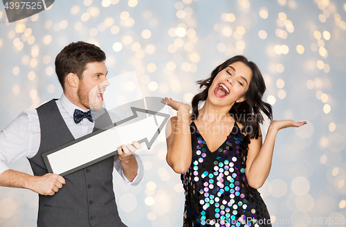 Image of happy couple with big arrow at party