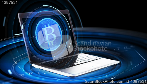 Image of laptop computer with bitcoin hologram