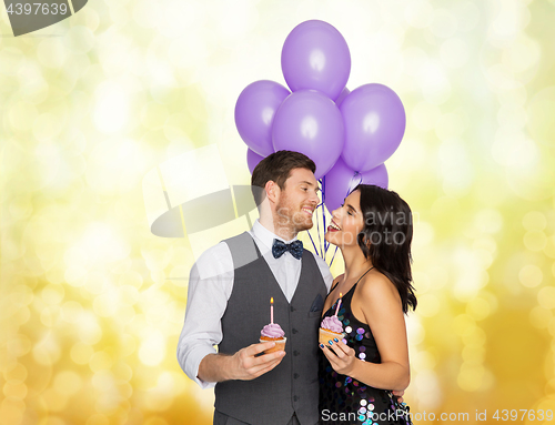 Image of happy couple with balloons and cupcakes at party