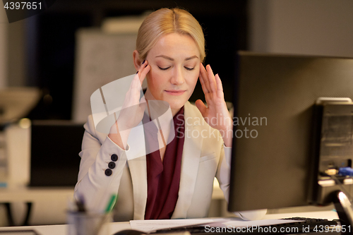 Image of businesswoman with computer at night office