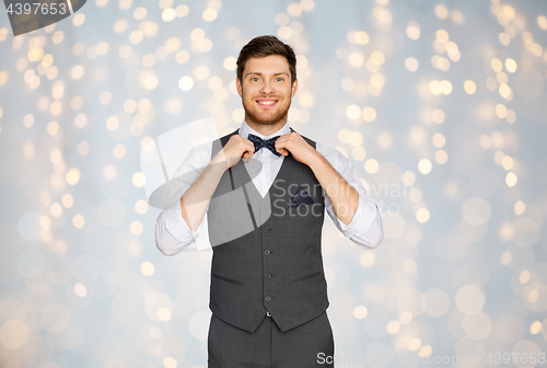 Image of happy man in festive suit dressing for party