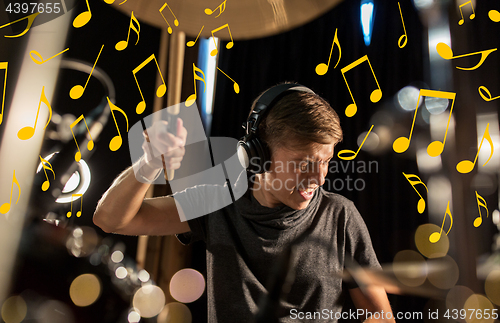 Image of musician in headphones playing drum kit at concert