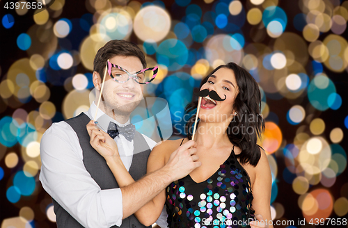 Image of happy couple with party props having fun