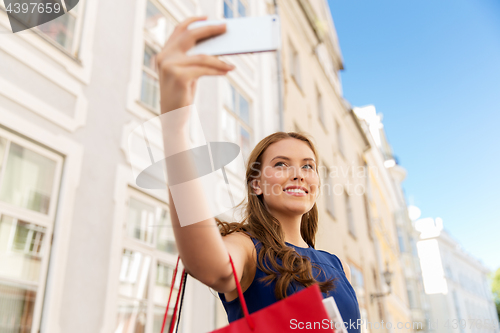 Image of woman shopping and taking selfie by smartphone