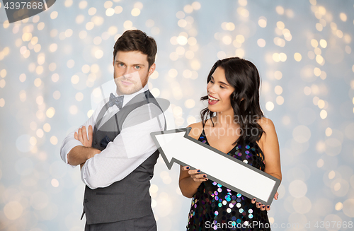 Image of happy couple with big arrow at party