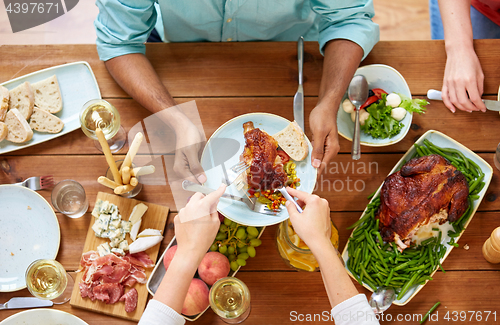 Image of group of people eating chicken for dinner