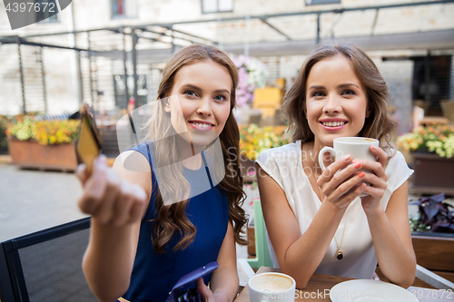 Image of young women paying for coffee at street cafe