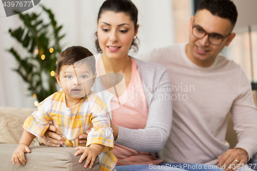Image of happy family with baby daughter at home