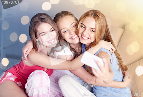 Image of teen girls with smartphone taking selfie at home