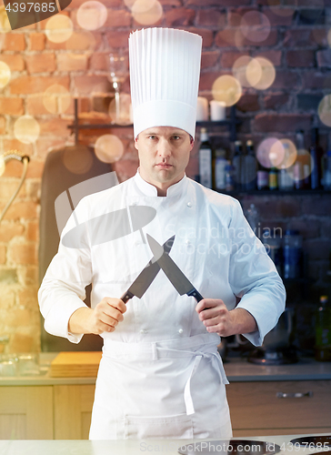 Image of happy male chef cook in kitchen with knife