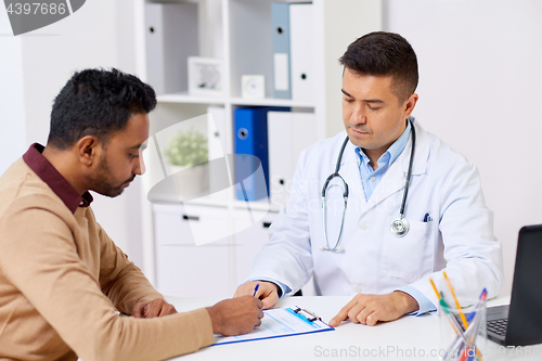 Image of doctor and patient signing document at clinic