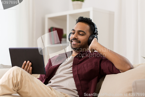 Image of man in phones with tablet pc listening to music