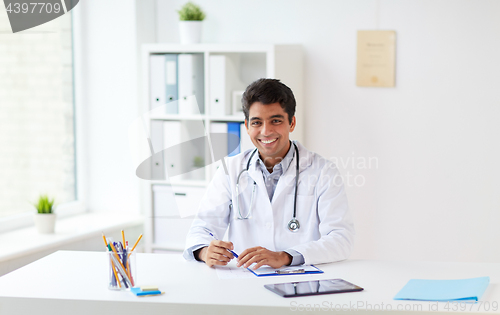 Image of happy doctor with clipboard at clinic