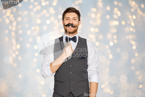 Image of happy young man with fake mustache at party